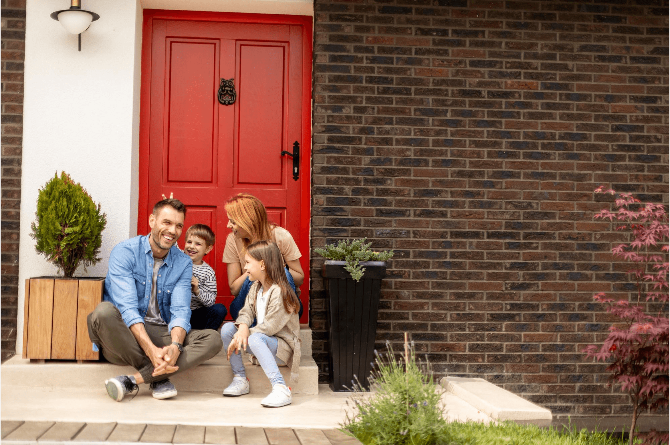 Família feliz em frente de sua casa própria