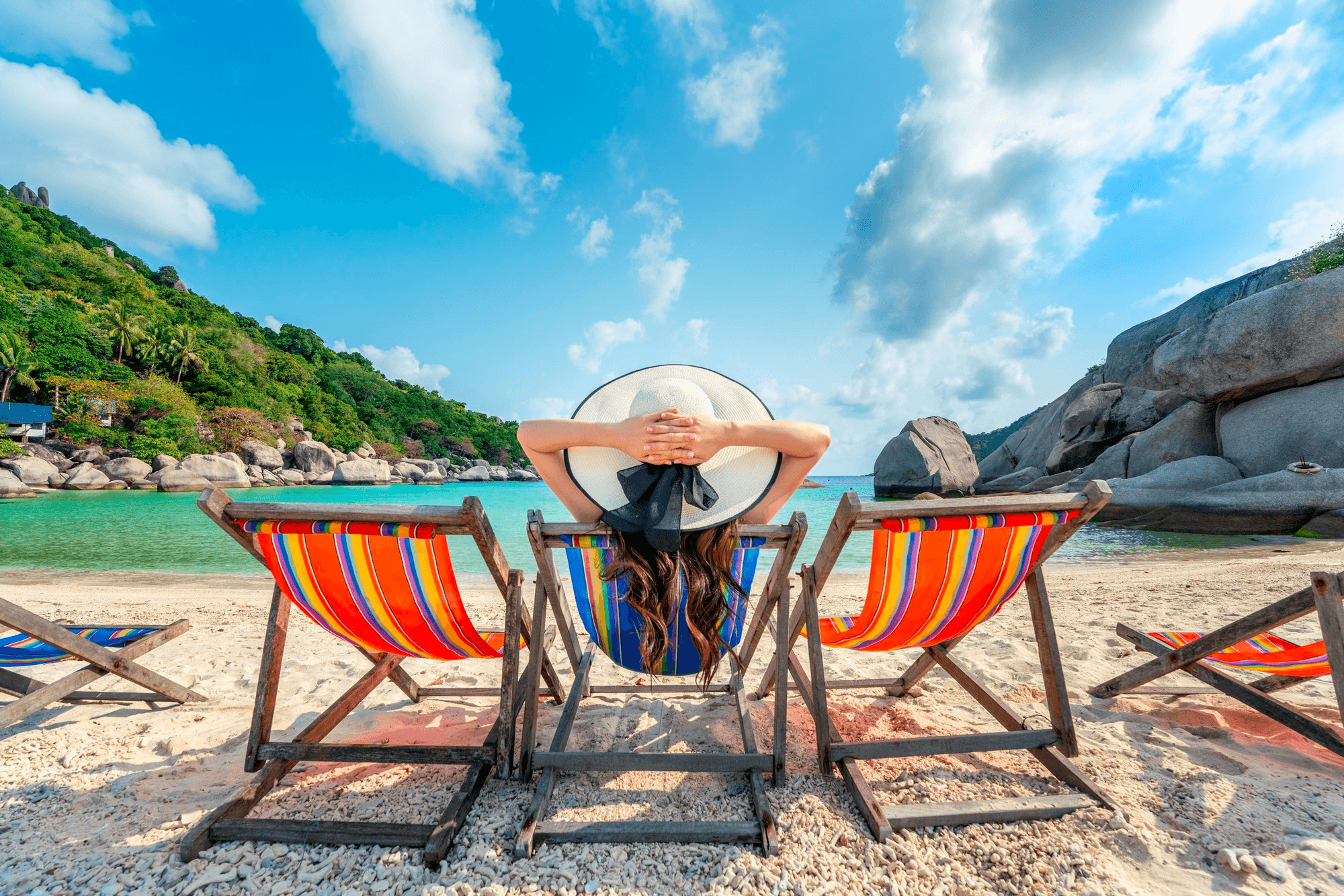 Experiências inesquecíveis são as suas melhores metas de vida Cliente do consórcio de serviços Embracon sentada em espreguiçadeira na praia cercada por montanhas